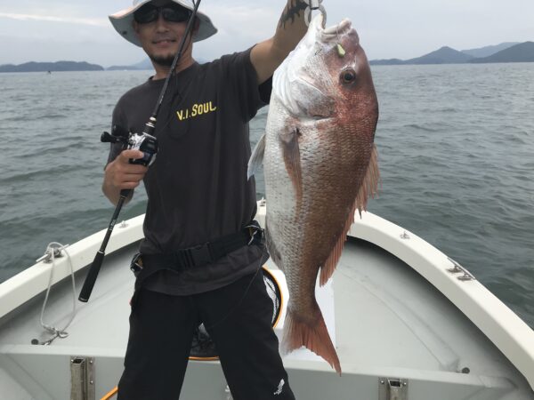 V.I.SOULのTシャツを着て大鯛を掲げる田中真。笠岡沖のボートにて一つテンヤで釣り上げた見事な釣果。